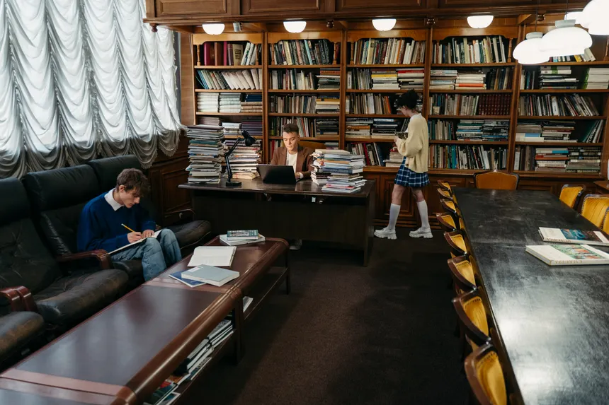 Students engaging in study and research within a classic library setting.