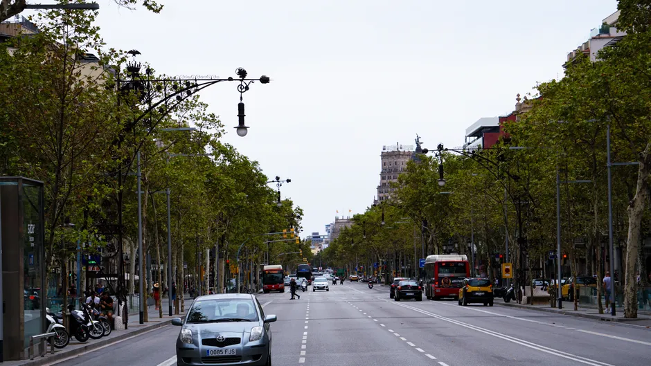 A bustling street view in Barcelona capturing urban transport and architecture.