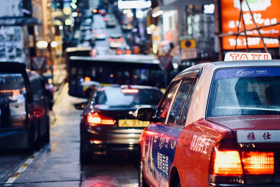 Bustling night traffic in Hong Kong city streets, showcasing urban life and vibrant lights.