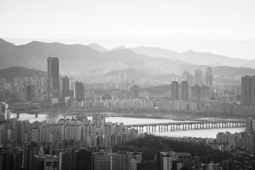 A stunning black and white view of Seoul's skyline featuring the Hangang River and modern skyscrapers.