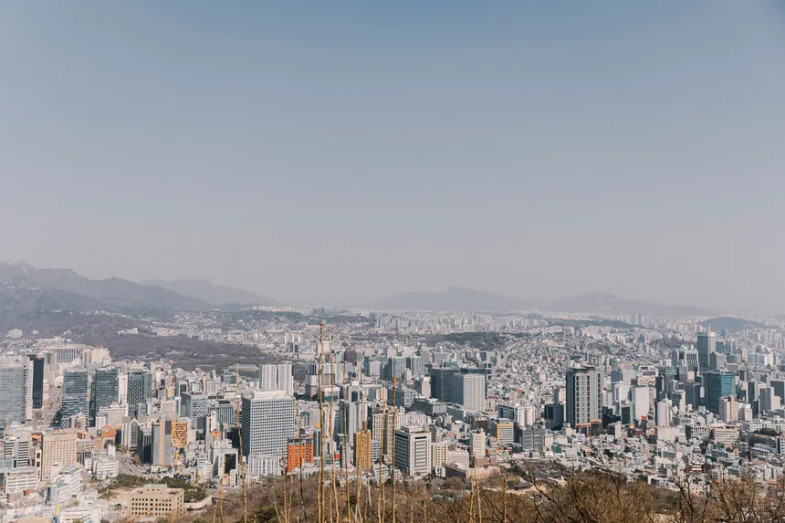 Stunning aerial view of Seoul with clear skies, showcasing skyscrapers and urban landscape.