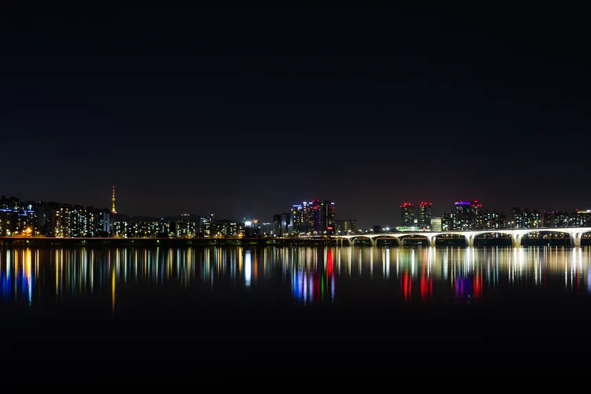 Stunning night view of Seoul's illuminated skyline reflected over the Han River.